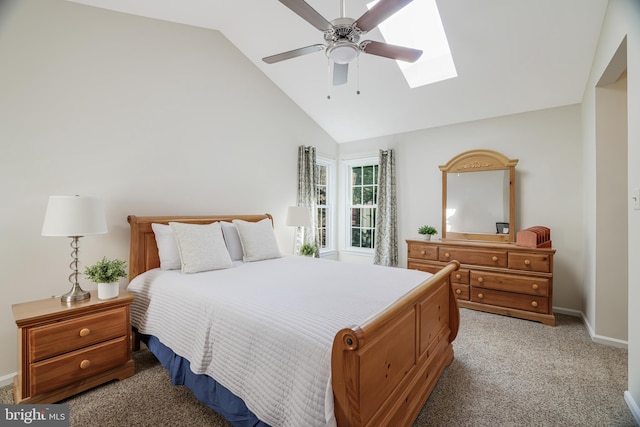 bedroom with a skylight, light carpet, ceiling fan, high vaulted ceiling, and baseboards