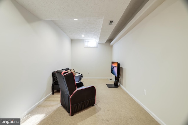 sitting room featuring light colored carpet, visible vents, a textured ceiling, and baseboards