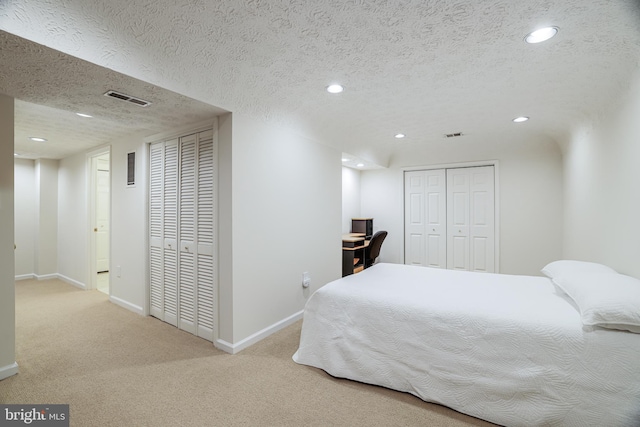 carpeted bedroom with recessed lighting, visible vents, a textured ceiling, and baseboards