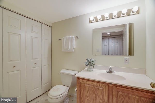 half bath featuring a closet, vanity, and toilet