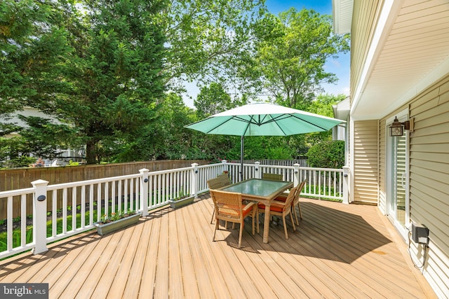 deck with outdoor dining area and fence