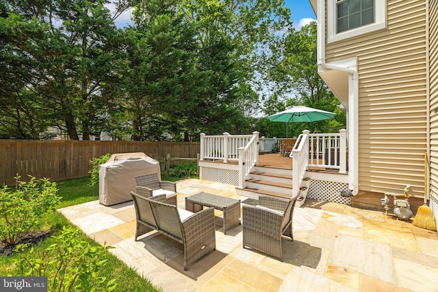 view of patio featuring a deck, outdoor lounge area, a fenced backyard, and area for grilling