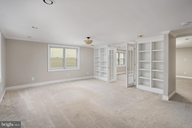 unfurnished room with crown molding, plenty of natural light, and light carpet