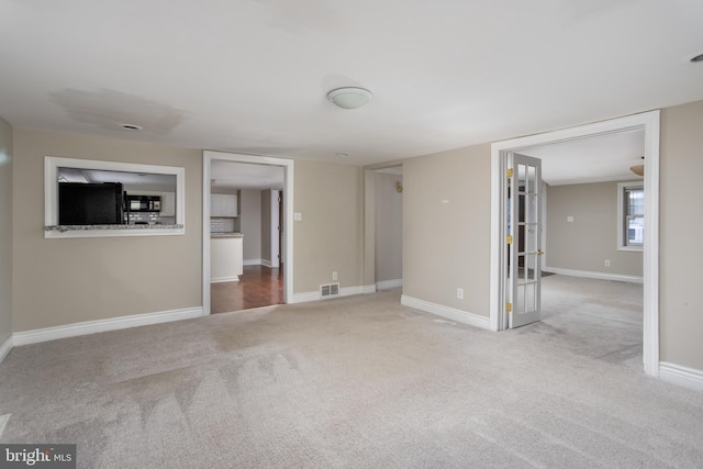 unfurnished living room featuring light carpet