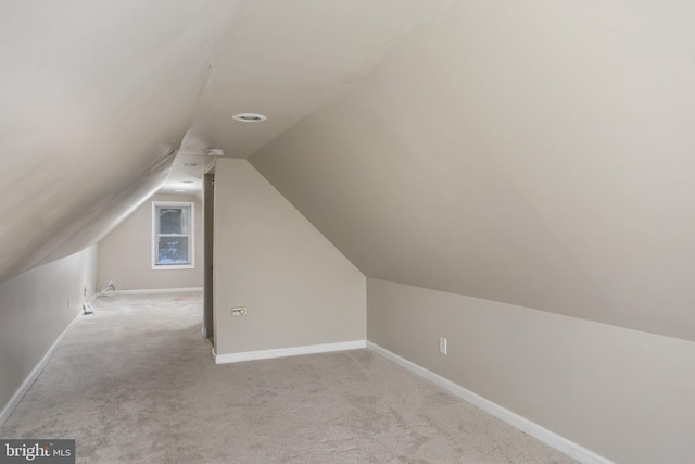 bonus room featuring lofted ceiling and light colored carpet