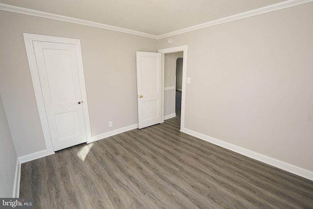 unfurnished bedroom with dark hardwood / wood-style flooring and ornamental molding