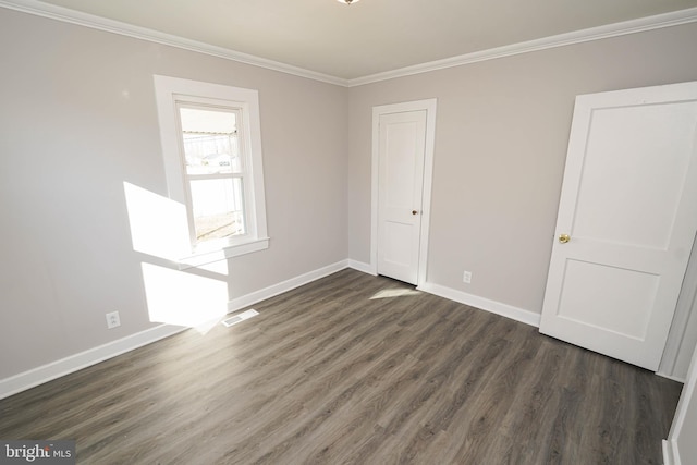 spare room featuring crown molding and dark hardwood / wood-style flooring