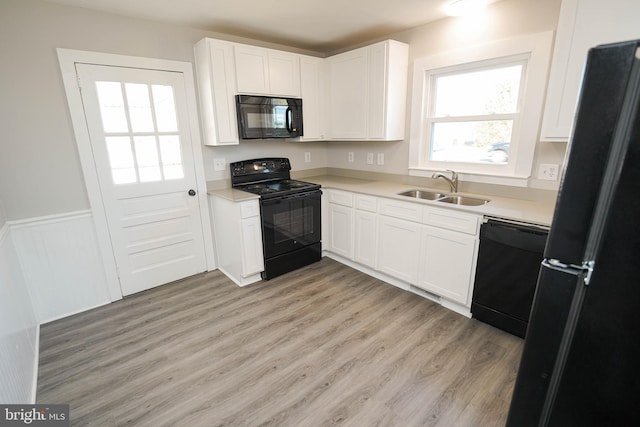 kitchen featuring sink, black appliances, and white cabinets