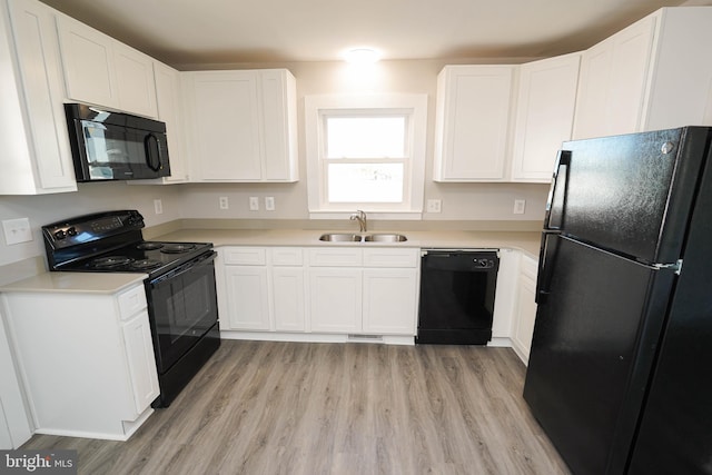 kitchen featuring sink, white cabinets, and black appliances