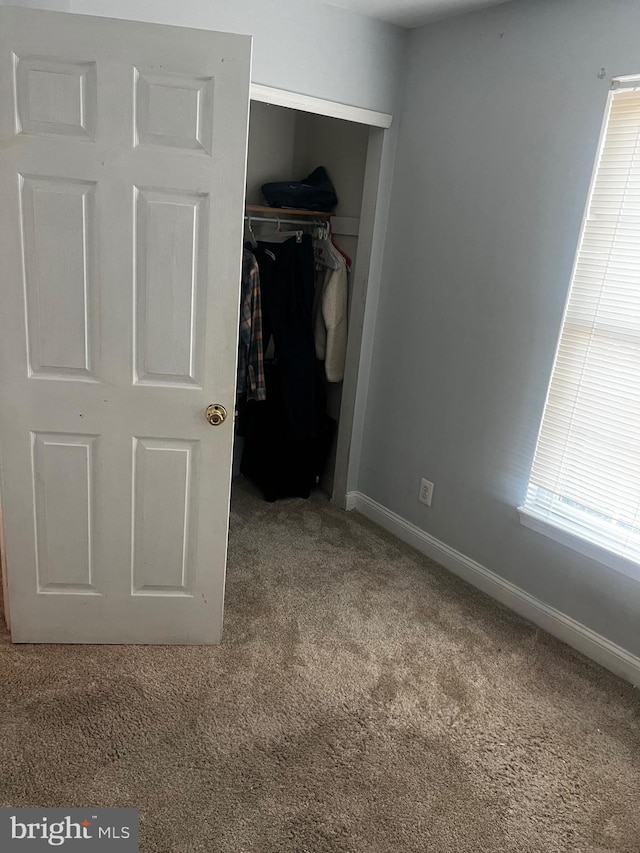 unfurnished bedroom featuring carpet floors and a closet