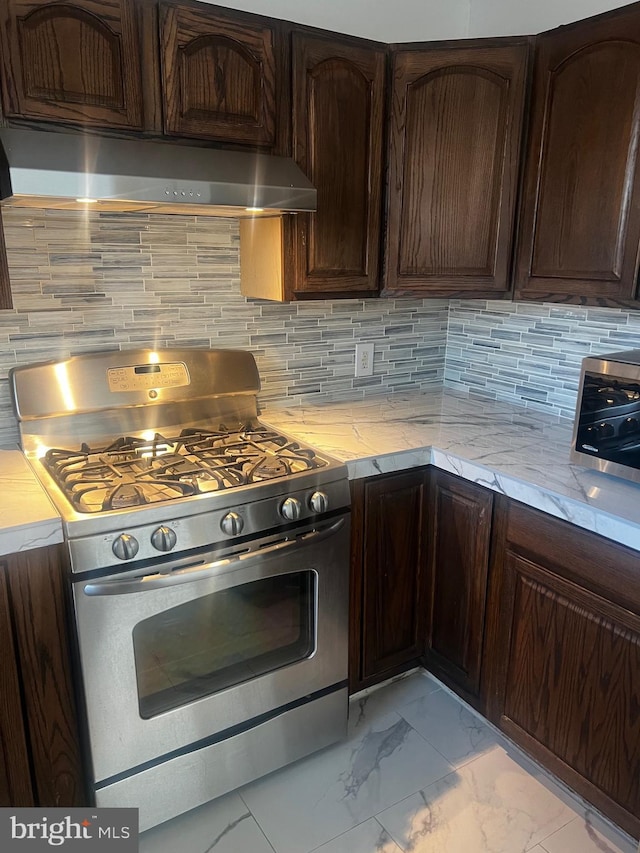 kitchen with gas stove, dark brown cabinetry, and decorative backsplash