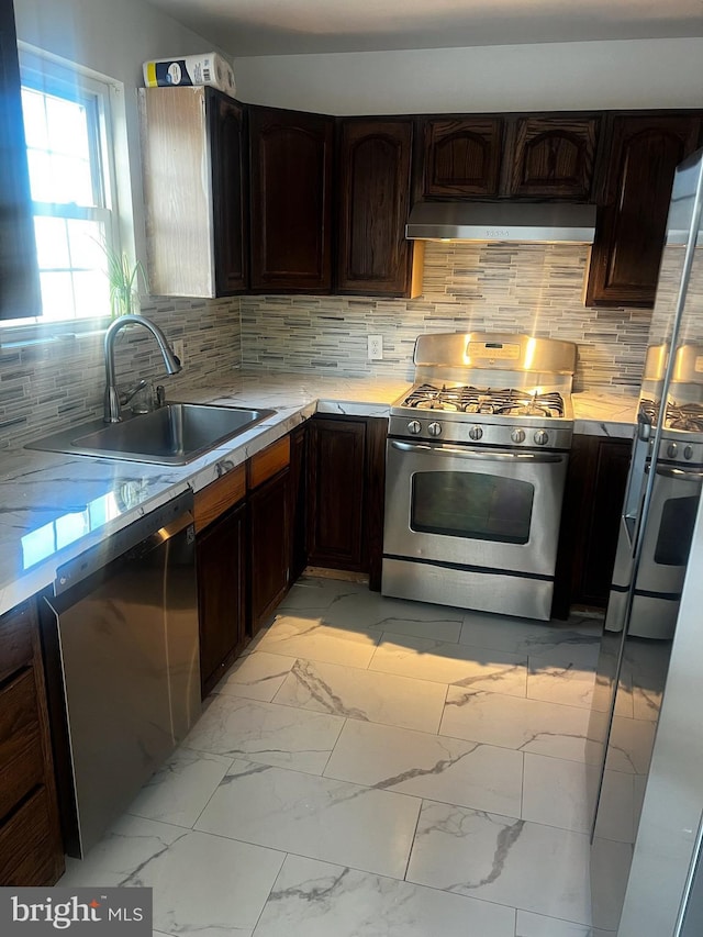 kitchen featuring stainless steel appliances, tasteful backsplash, sink, and dark brown cabinetry