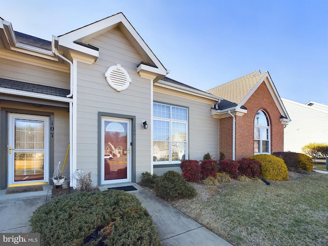 view of exterior entry with a yard