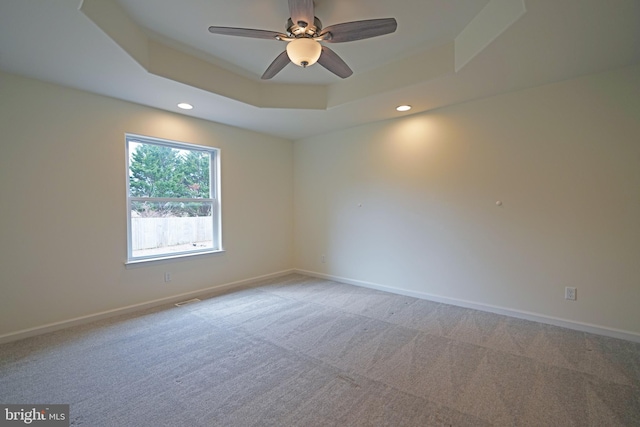 unfurnished room with visible vents, baseboards, a raised ceiling, light colored carpet, and recessed lighting