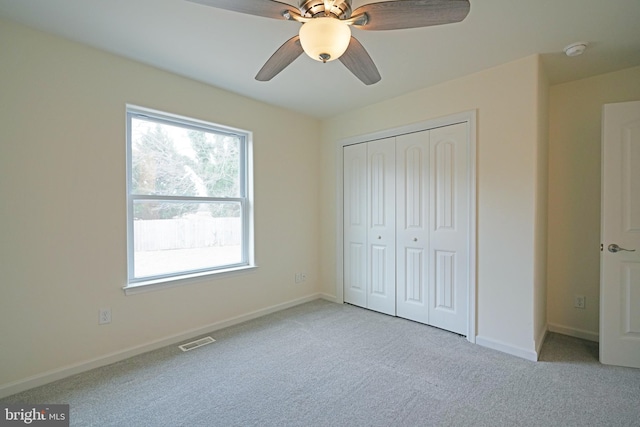 unfurnished bedroom featuring a closet, visible vents, light carpet, and baseboards