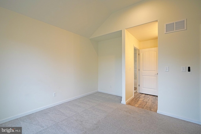 unfurnished bedroom featuring vaulted ceiling, carpet flooring, visible vents, and baseboards