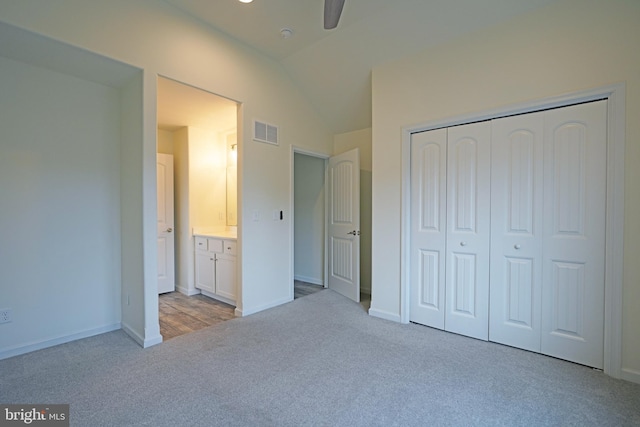 unfurnished bedroom with baseboards, visible vents, lofted ceiling, carpet flooring, and a closet