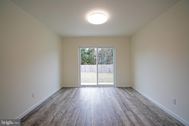 spare room with wood finished floors and baseboards