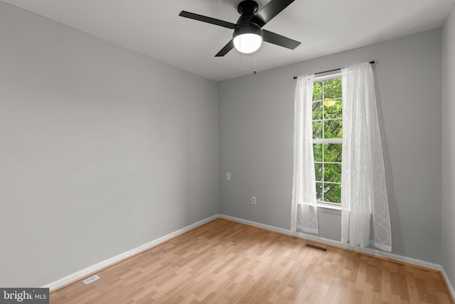 unfurnished room featuring light wood-type flooring, visible vents, a ceiling fan, and baseboards