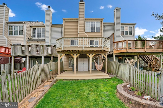 back of property with a fenced backyard, a yard, a deck, and cooling unit