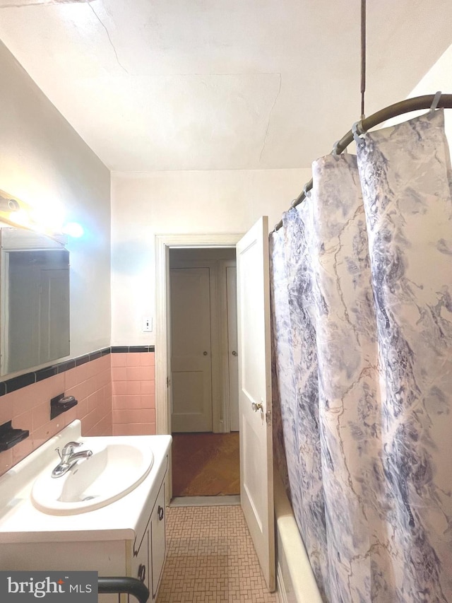 bathroom with tile walls, vanity, tile patterned flooring, and shower / bath combo with shower curtain