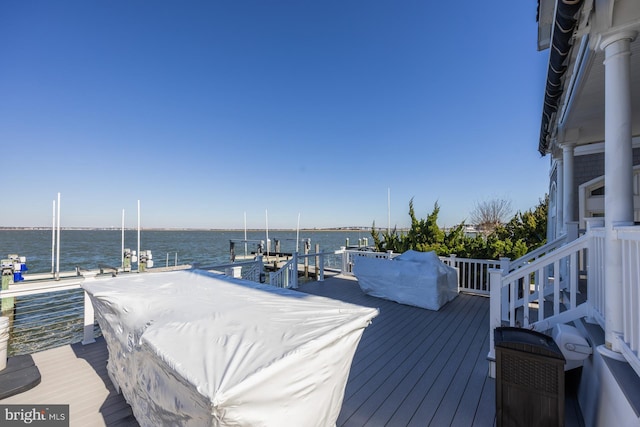 wooden terrace featuring a water view and a dock