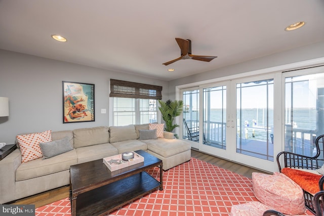 living room featuring a water view, ceiling fan, and wood-type flooring