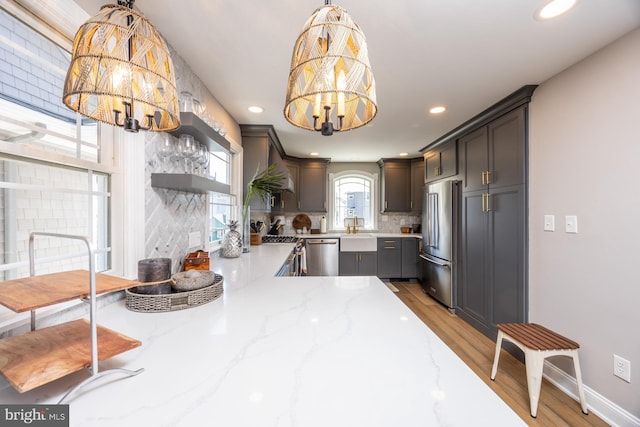 kitchen featuring hanging light fixtures, high end appliances, a chandelier, and decorative backsplash