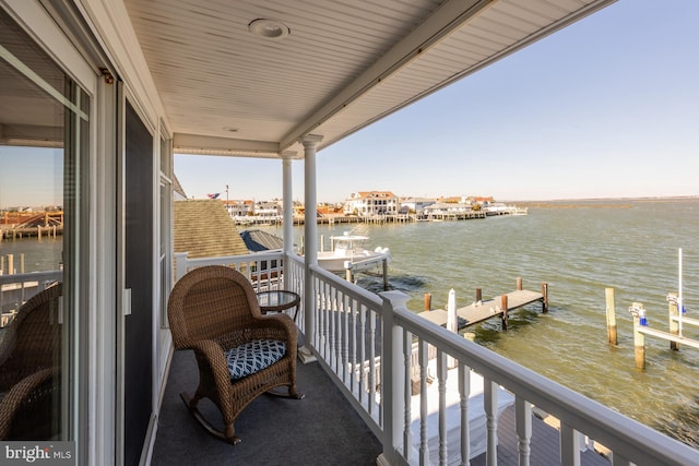 balcony with a water view and a dock