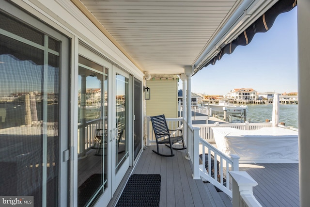 balcony with a water view and french doors