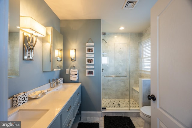 bathroom with vanity, a shower with shower door, tile patterned floors, and toilet