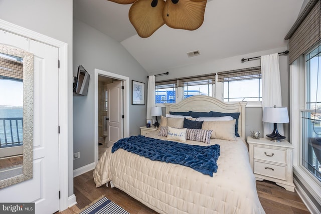 bedroom featuring dark wood-type flooring, ensuite bath, lofted ceiling, and ceiling fan