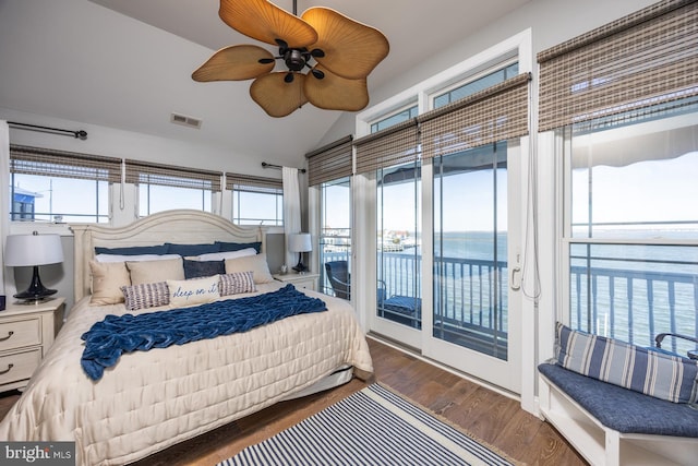 bedroom featuring dark wood-type flooring, ceiling fan, vaulted ceiling, a water view, and access to outside