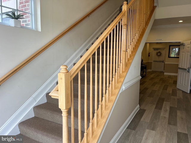 staircase featuring ornamental molding, wood finished floors, and recessed lighting