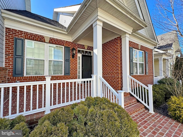 view of exterior entry featuring brick siding