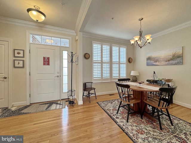 foyer featuring visible vents, baseboards, light wood-type flooring, ornamental molding, and an inviting chandelier