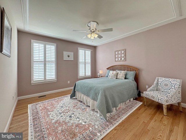 bedroom featuring visible vents, baseboards, a ceiling fan, and light wood finished floors