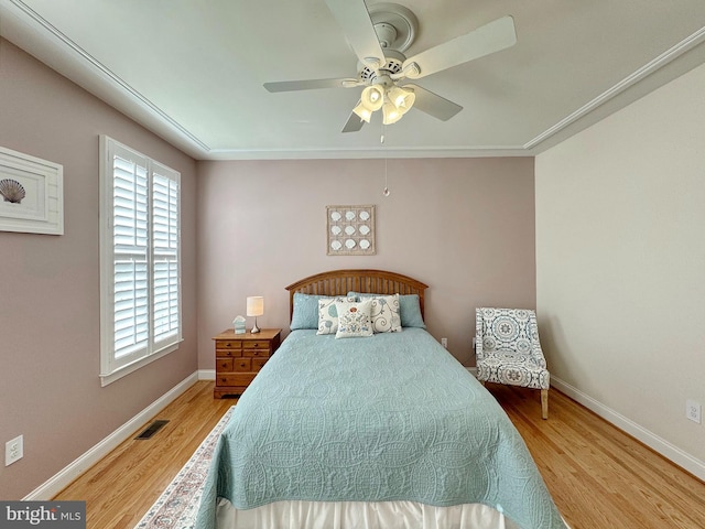 bedroom with visible vents, a ceiling fan, baseboards, and wood finished floors