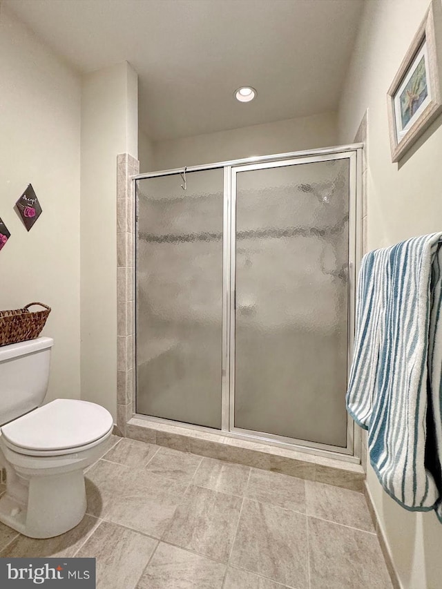 bathroom with a shower stall and toilet