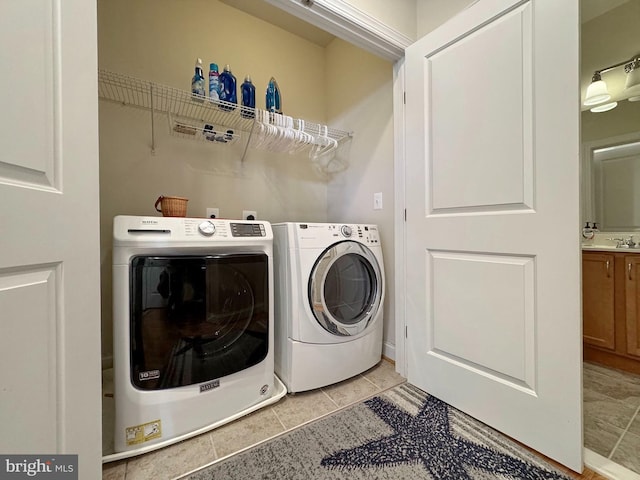 laundry room with light tile patterned floors, laundry area, independent washer and dryer, and a sink