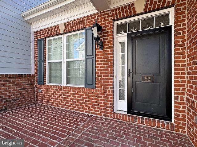 view of exterior entry with brick siding