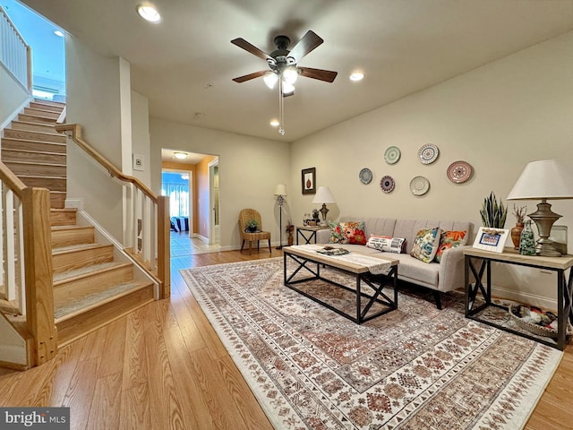 living area with baseboards, ceiling fan, stairs, recessed lighting, and wood finished floors