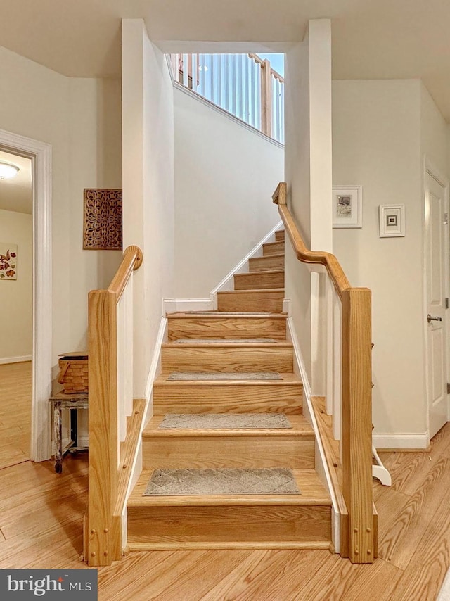 stairs with baseboards and wood finished floors