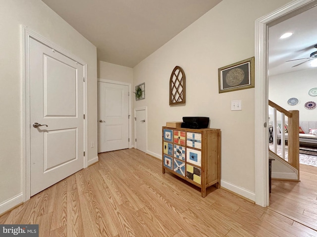 corridor featuring baseboards and light wood finished floors