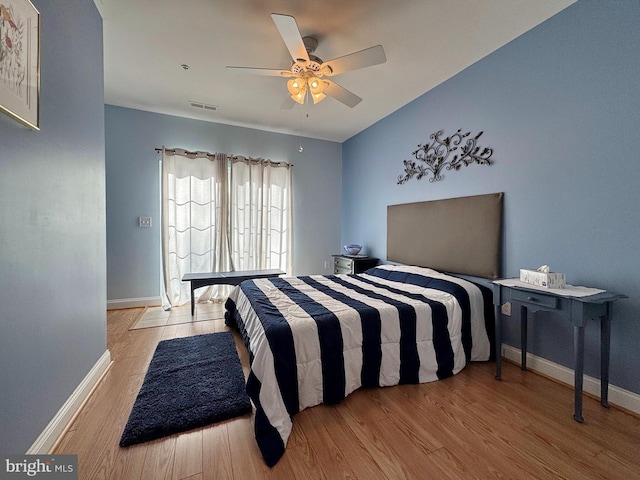 bedroom featuring visible vents, baseboards, and wood finished floors