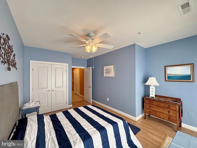 bedroom with visible vents, a ceiling fan, a closet, light wood finished floors, and baseboards