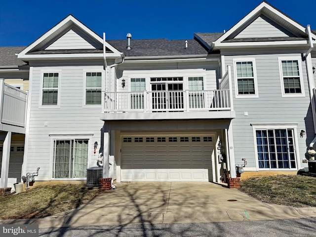 townhome / multi-family property with cooling unit, an attached garage, a balcony, and driveway