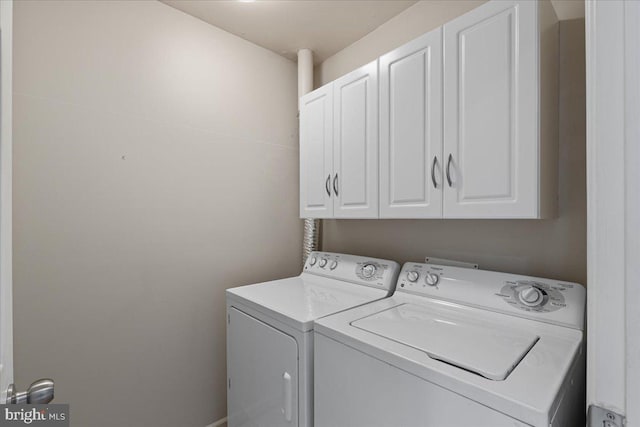 clothes washing area with cabinet space and washing machine and dryer