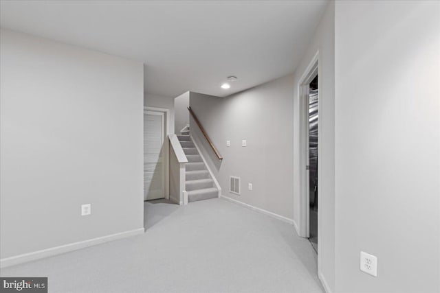 basement with stairs, carpet flooring, visible vents, and baseboards