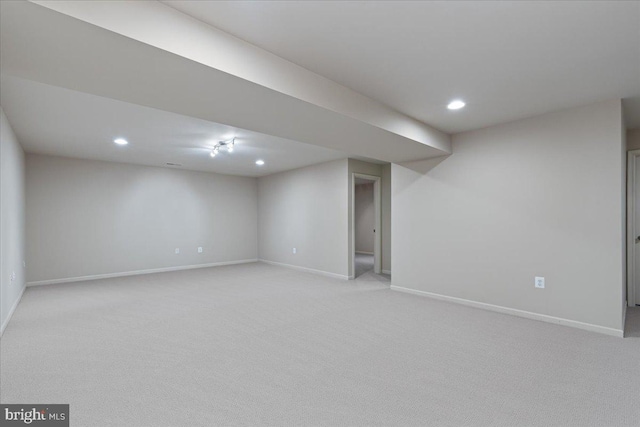 finished below grade area featuring recessed lighting, baseboards, and light colored carpet